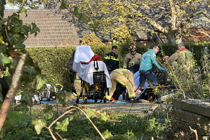 Man gewond na beknelling onder graafmachine