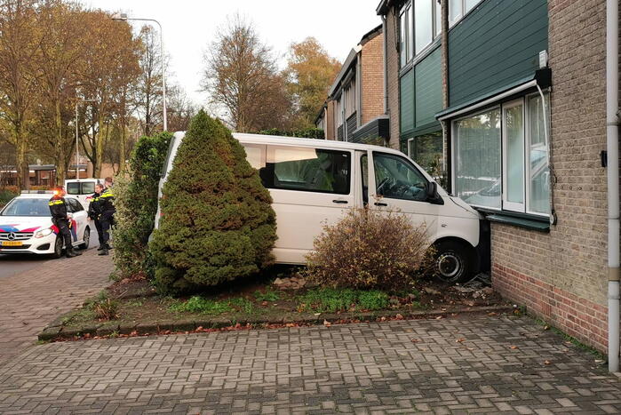 Taxibus met kinderen rijdt tegen woning