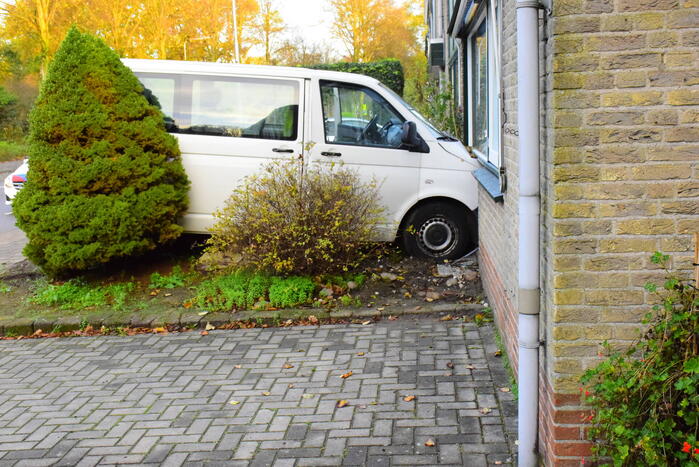 Taxibus met kinderen rijdt tegen woning