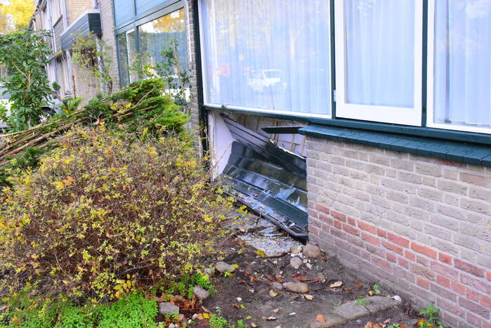 Taxibus met kinderen rijdt tegen woning