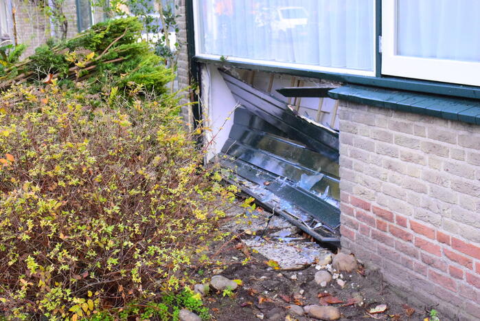 Taxibus met kinderen rijdt tegen woning