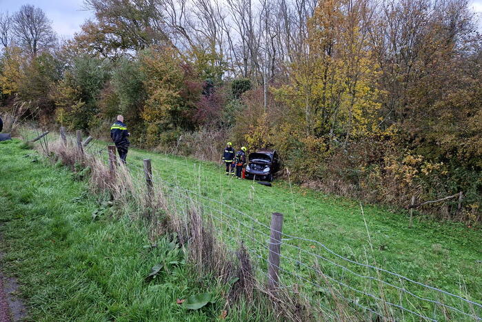 Auto rolt van de dijk af