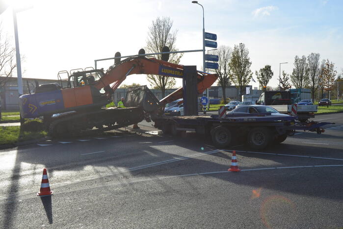 Graafmachine valt van dieplader