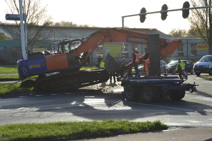 Graafmachine valt van dieplader