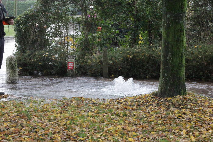 Straat onderwater door gesprongen waterleiding