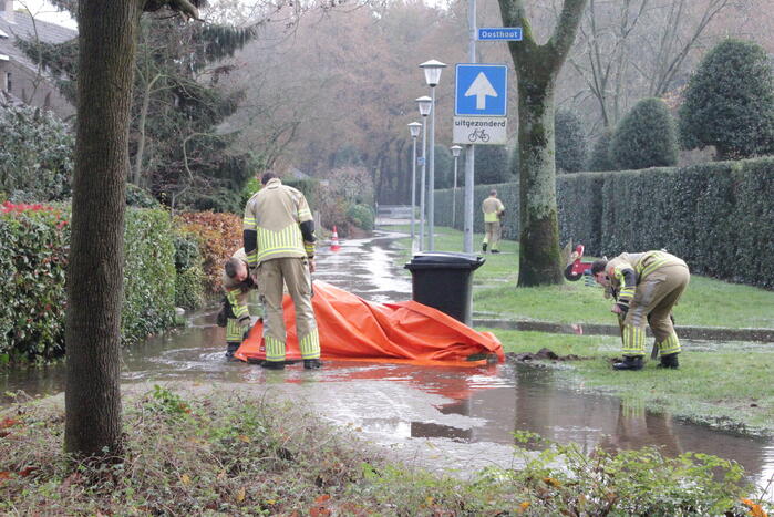 Straat onderwater door gesprongen waterleiding