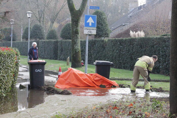 Straat onderwater door gesprongen waterleiding