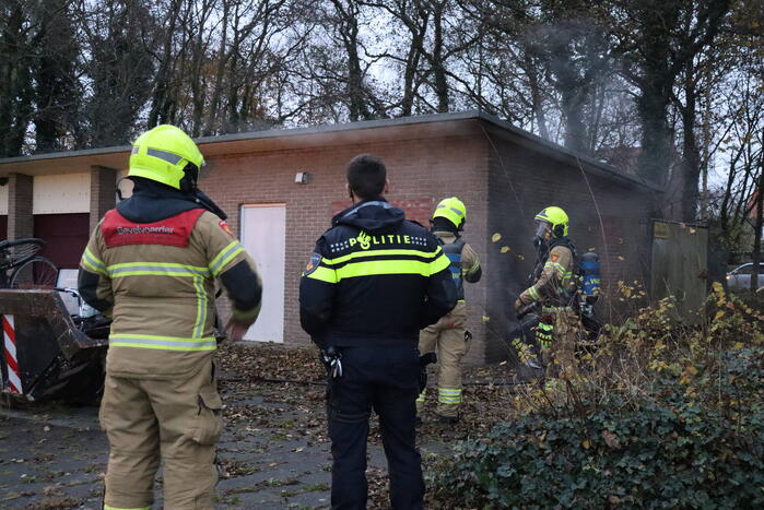 Wasmachine in brand tegen gebouw