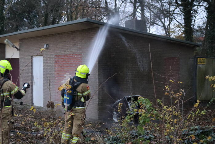 Wasmachine in brand tegen gebouw