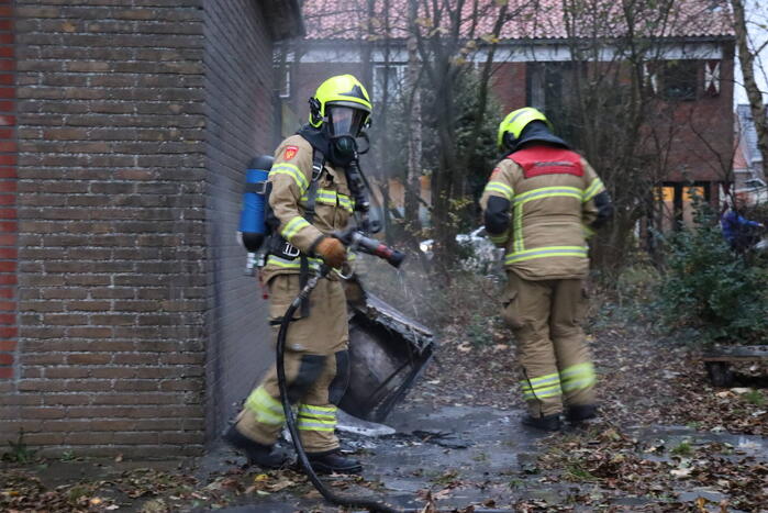 Wasmachine in brand tegen gebouw