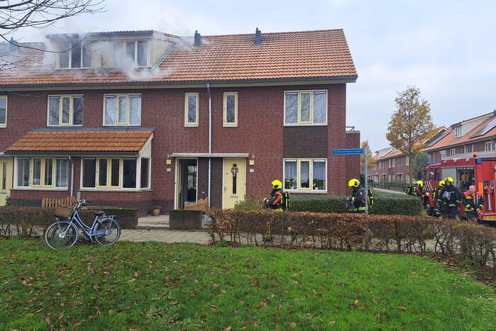 Veel rook uit dakkapel bij woningbrand