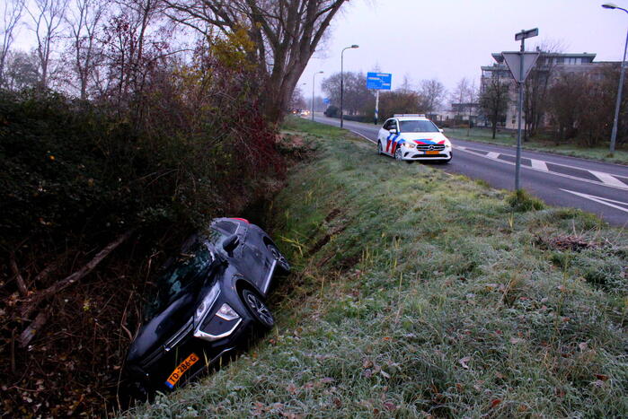Auto raakt van de weg en belandt half in de sloot