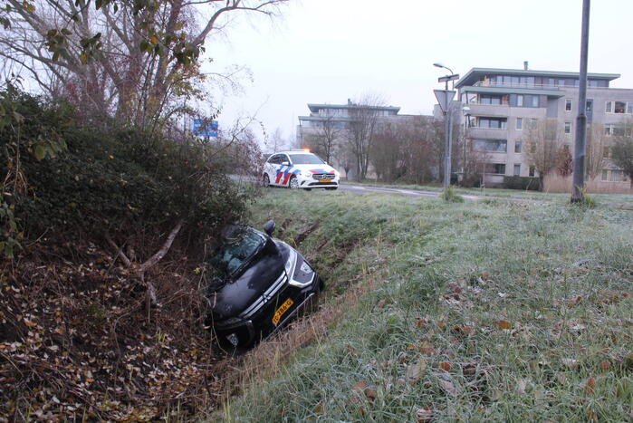 Auto raakt van de weg en belandt half in de sloot