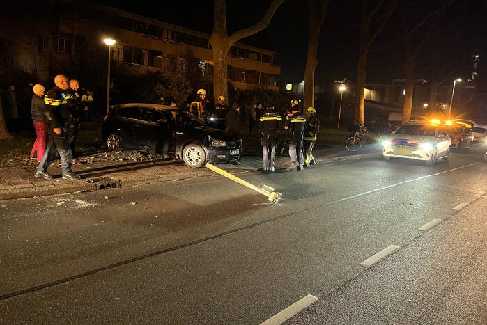 Automobilist ramt lantaarnpaal en elektriciteitskast