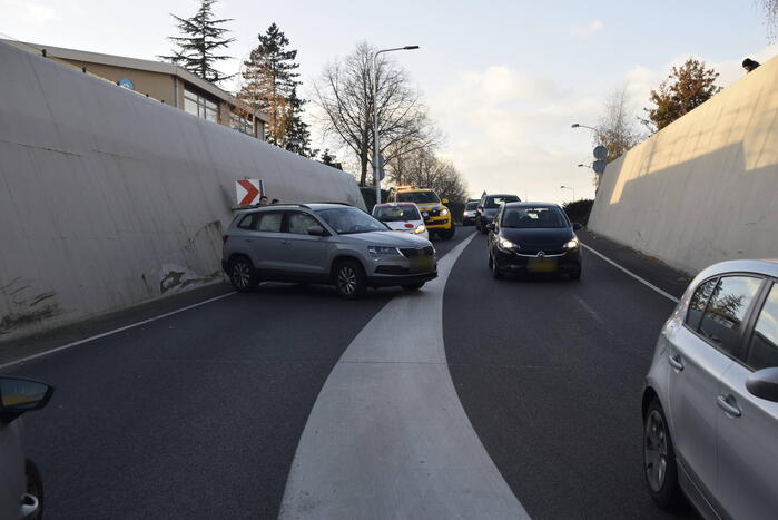 Twee auto's botsen onder spoortunnel