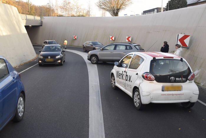 Twee auto's botsen onder spoortunnel