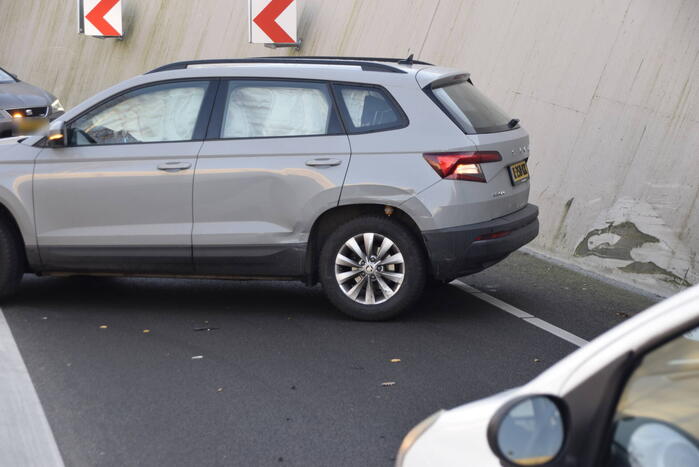 Twee auto's botsen onder spoortunnel