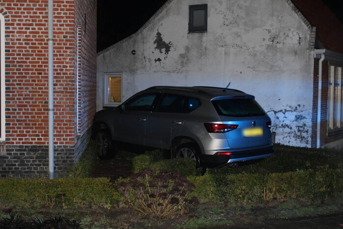 Auto glijdt door tegen woning