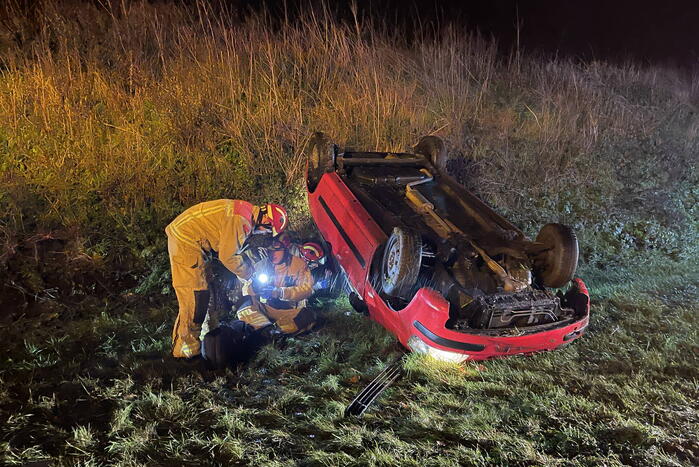 Auto belandt op de kop naast weg