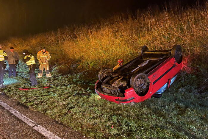 Auto belandt op de kop naast weg