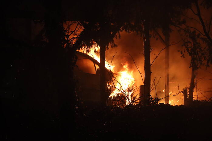 Personenauto vat vlam onder carport