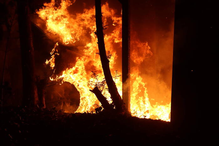Personenauto vat vlam onder carport