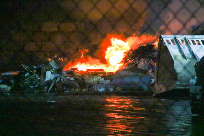 Berg met afval in brand op industrieterrein