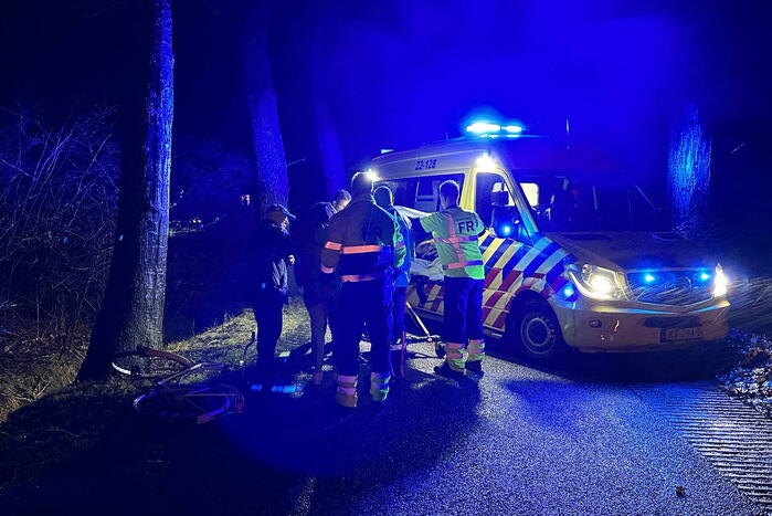 Hulp aan gevallen fietster op donkere weg