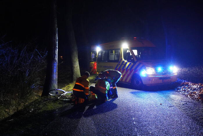 Hulp aan gevallen fietster op donkere weg