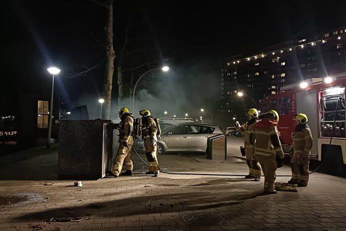 Brandweer blust in brand gestoken container