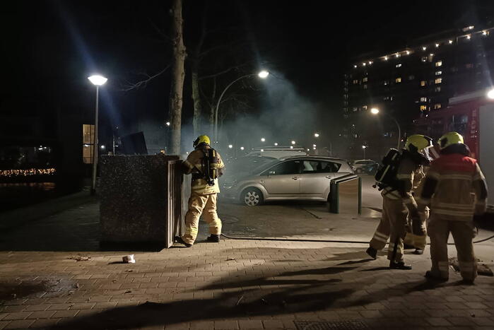 Brandweer blust in brand gestoken container