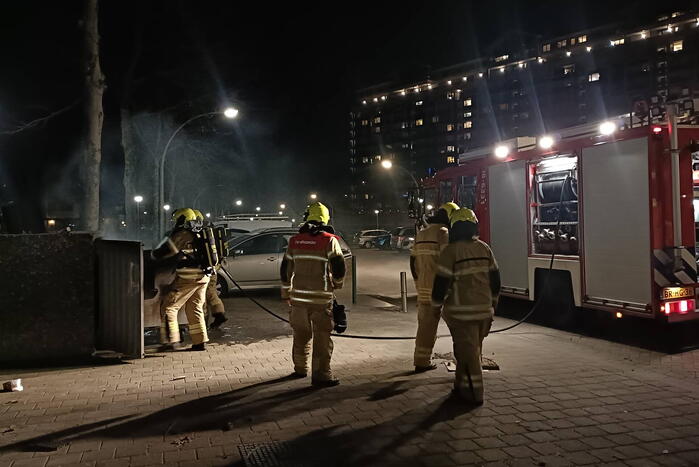 Brandweer blust in brand gestoken container