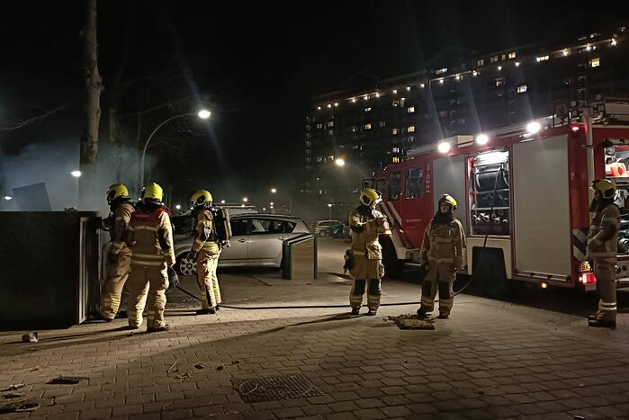 Brandweer blust in brand gestoken container
