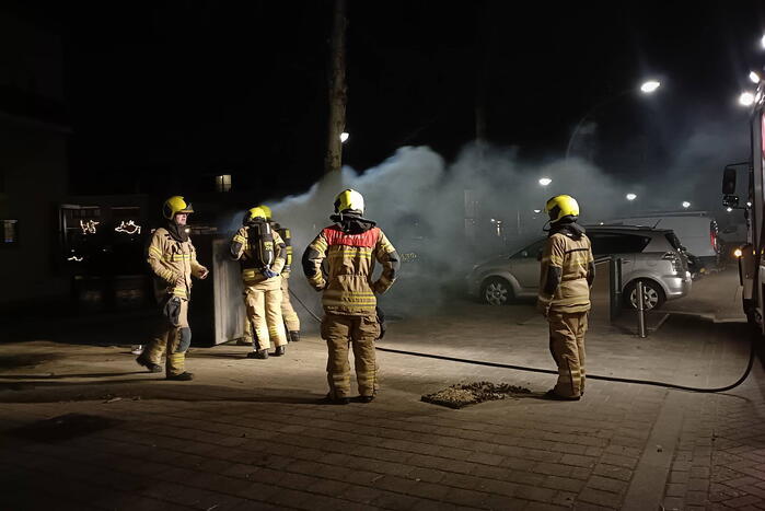 Brandweer blust in brand gestoken container
