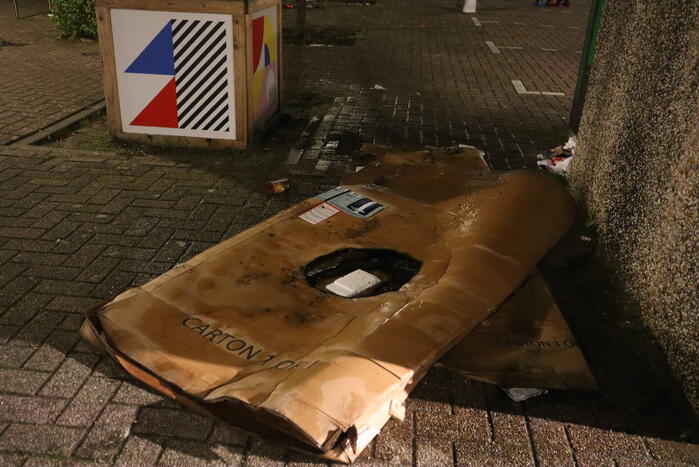 Brandweer blust brandende papiercontainer