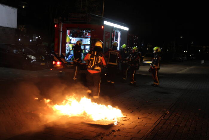Brandweer blust brandend afval