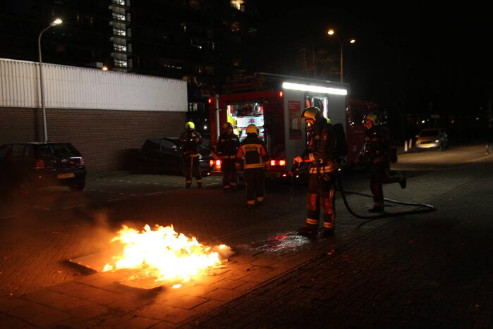 Brandweer blust brandend afval