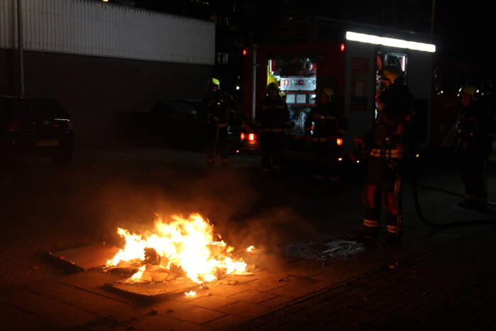 Brandweer blust brandend afval