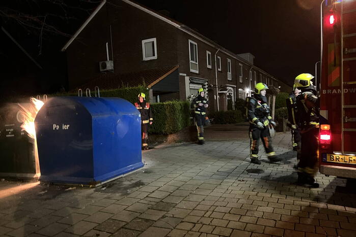 Brandweer blust rotzooi tussen containers