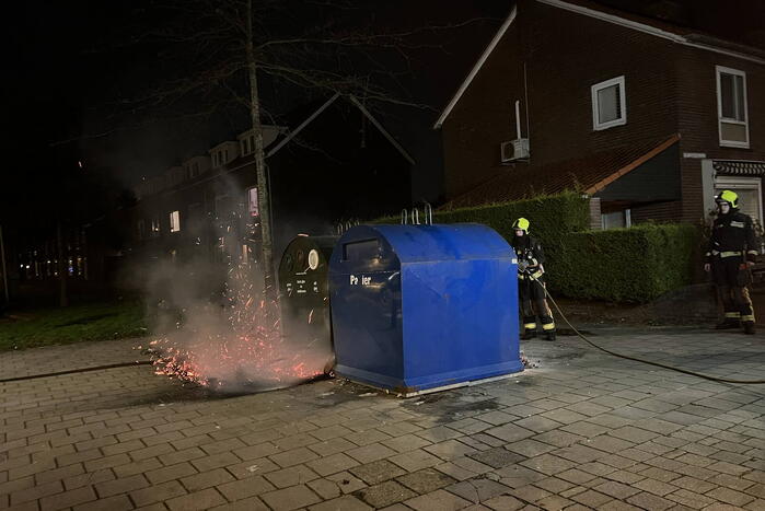 Brandweer blust rotzooi tussen containers