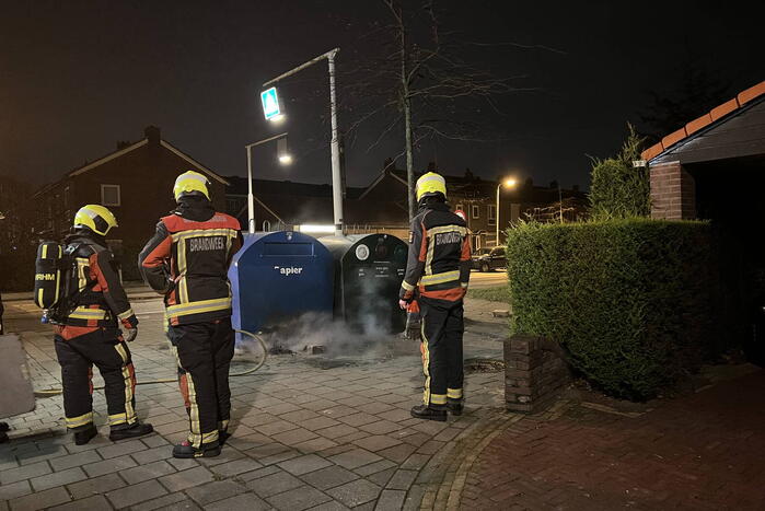 Brandweer blust rotzooi tussen containers