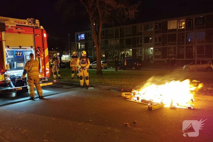 Brandweer blust berg afval op straat