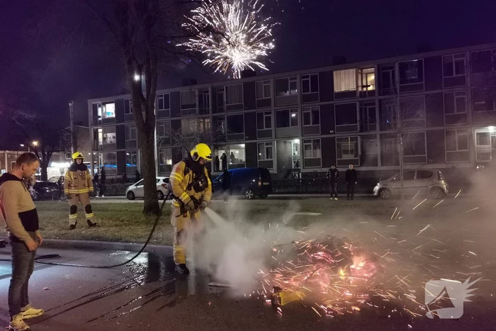 Brandweer blust berg afval op straat