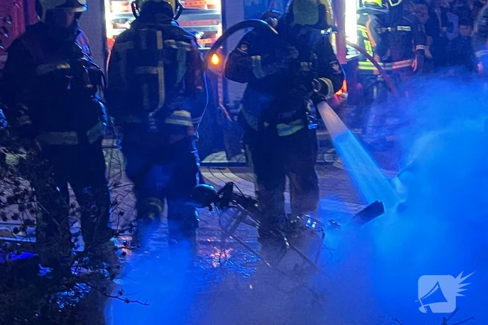 Brandweer blust brandende vuurton en scooter