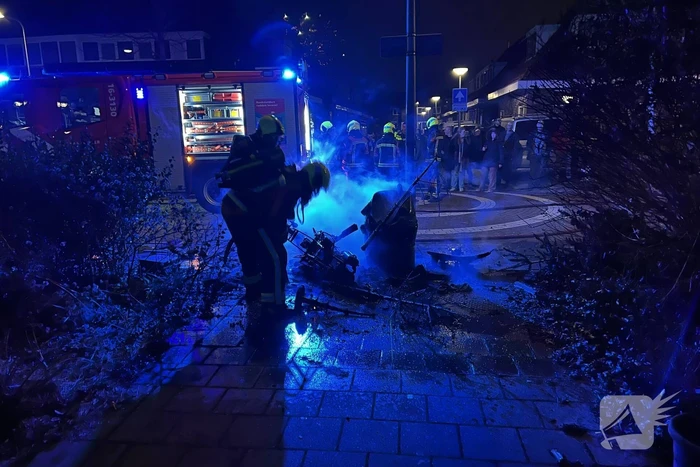 Brandweer blust brandende vuurton en scooter