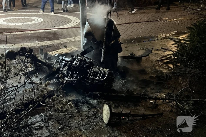 Brandweer blust brandende vuurton en scooter