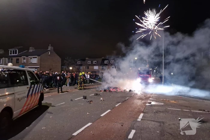 Brandweer blust brandend vuurwerkafval