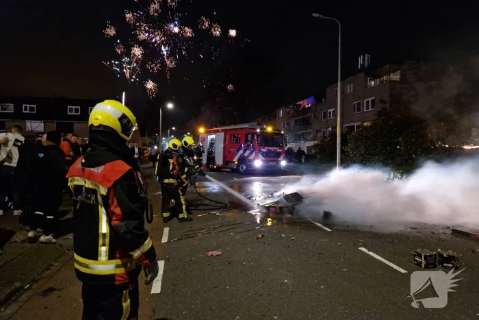 Brandweer blust brandend vuurwerkafval