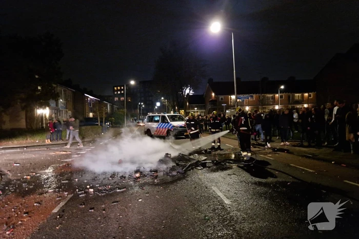 Brandweer blust brandend vuurwerkafval
