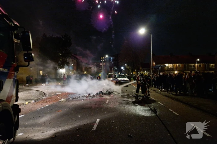 Brandweer blust brandend vuurwerkafval
